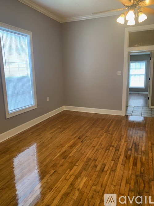A room with wooden flooring and a window.