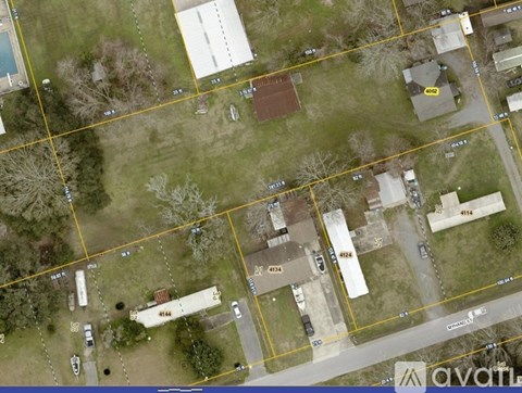 A satellite image shows a residential area with houses, roads, and vehicles.