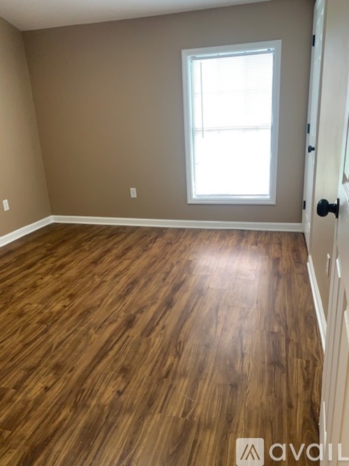 A room with wooden flooring and a window.