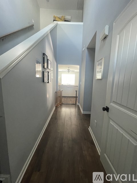 A hallway with wood floors and white walls.