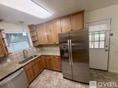 A kitchen with wooden cabinets and a stainless steel refrigerator.