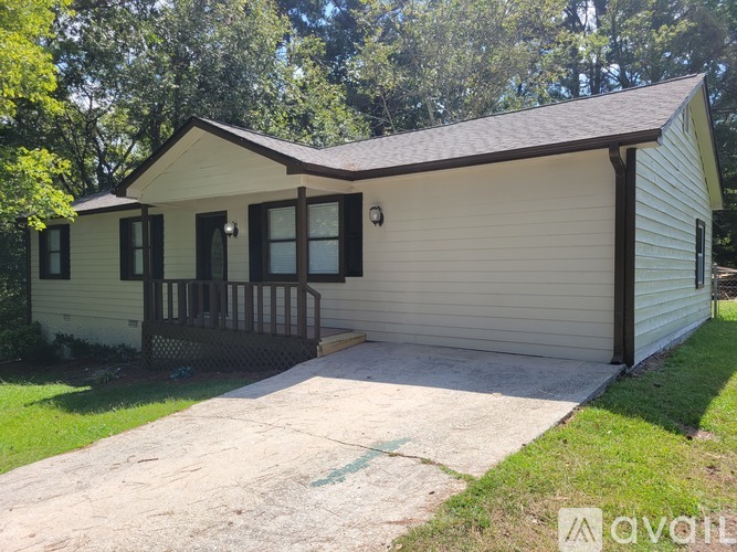 A small house with a porch and a covered garage.