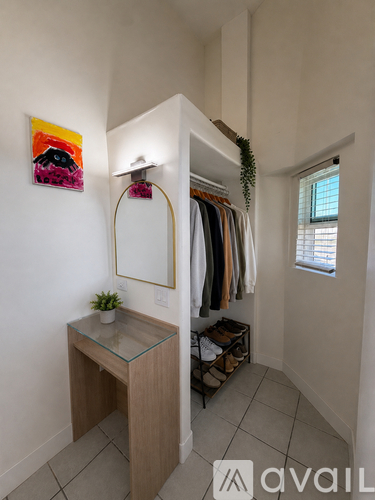 A room with a clothing rack and a mirror.