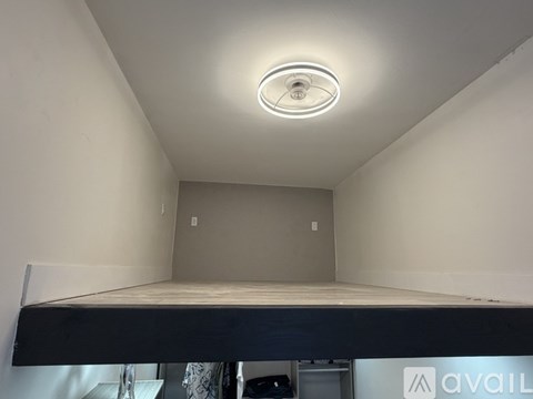 A room with a bed and a ceiling light.