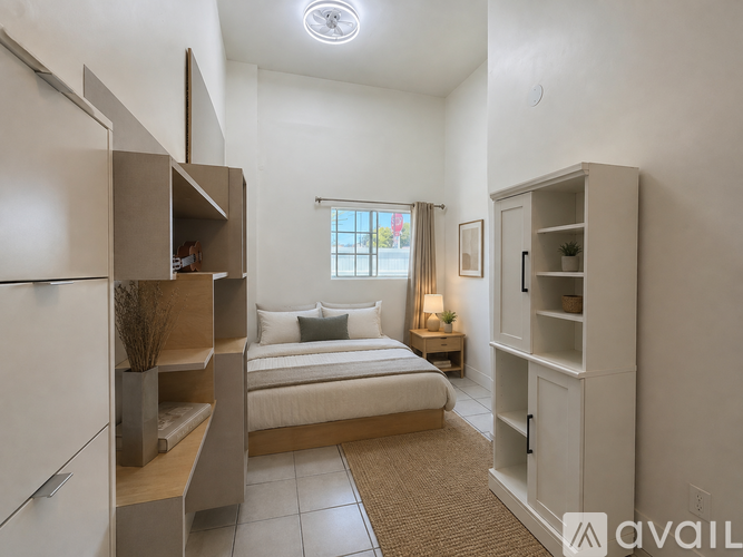A bedroom with a bed, a window, and a cabinet.