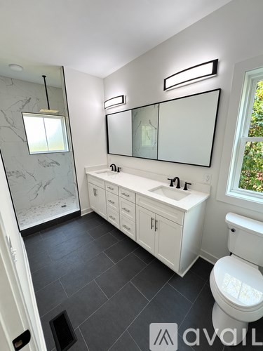 A bathroom with a toilet, sink, and mirror.