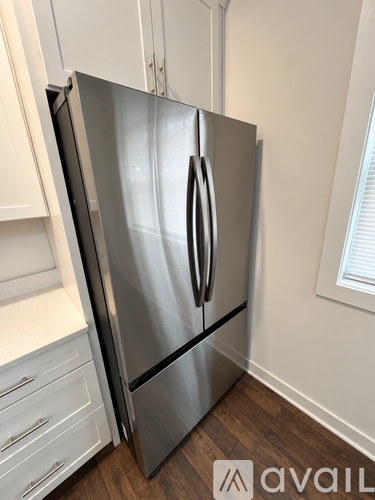 A stainless steel refrigerator with a white door is in a kitchen.