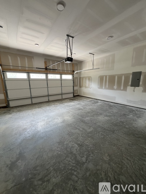 A spacious garage with a concrete floor and a hanging light fixture.