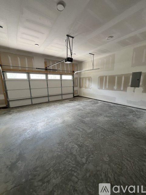 A spacious garage with a concrete floor and a hanging light fixture.