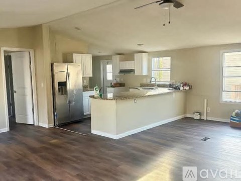 A kitchen with a refrigerator, sink, and cabinets.