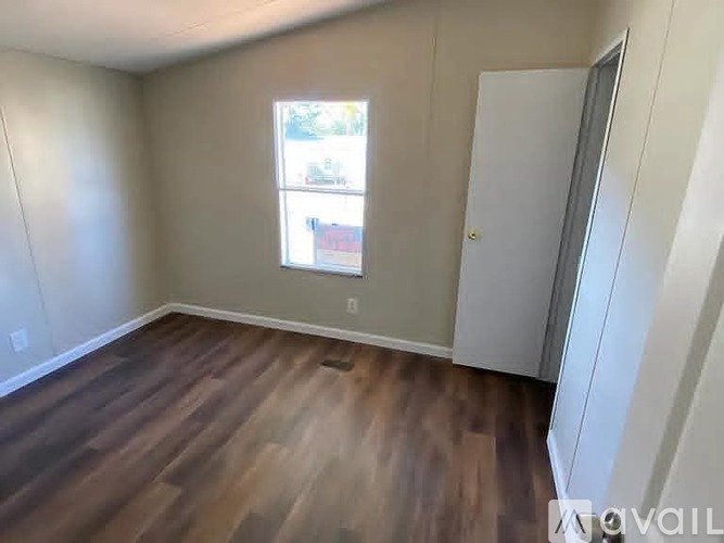 A room with a wooden floor and a white door.