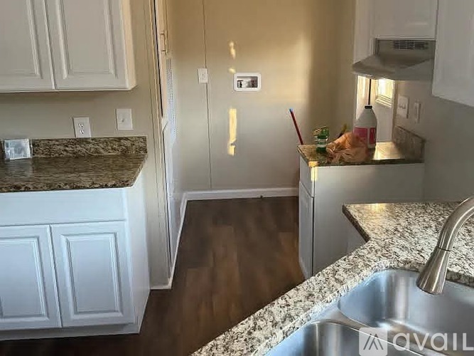 A kitchen with granite countertops and white cabinets.