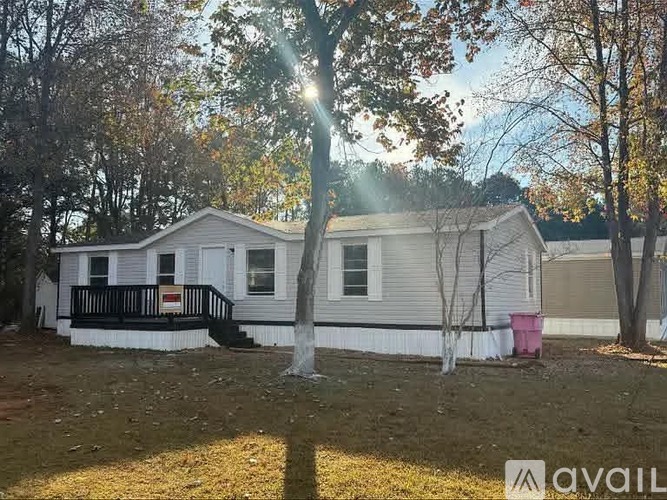 A house with a porch and a tree in front of it.
