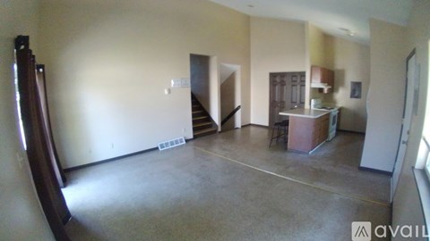 A room with a staircase and a kitchenette is available for rent.