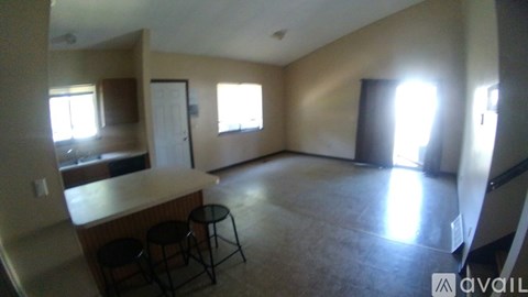 A living room with a bar and two stools.