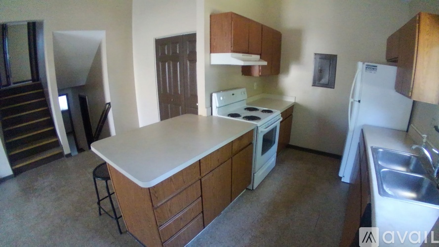 A kitchen with a white stove top oven and a white refrigerator.