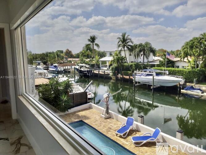 A view from a window looking out at a pool and boats.