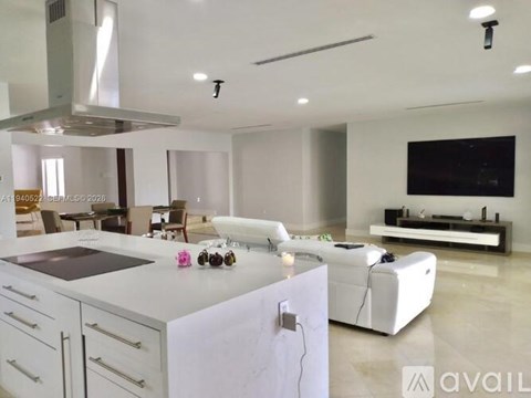 A modern kitchen with white cabinets and a large island.