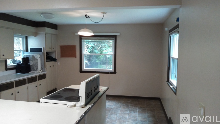 A kitchen with a microwave, oven, and a window.