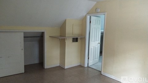 A room with a white door and a window with blinds.