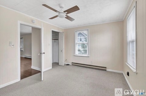A room with a ceiling fan and a window.