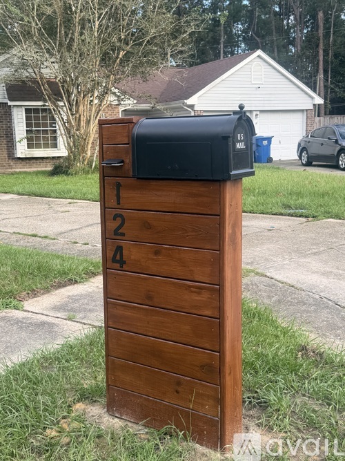A mailbox with the number 1244 on it is mounted on a wooden post.