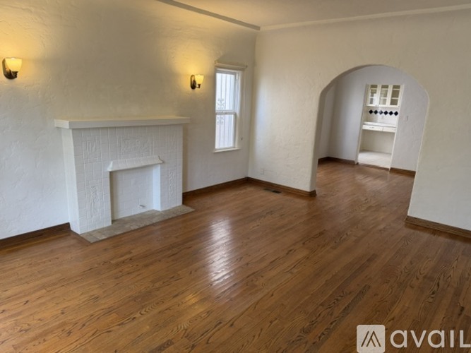 A room with a fireplace and wooden floors.