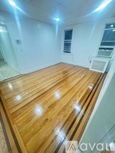 A room with wooden flooring and a window.