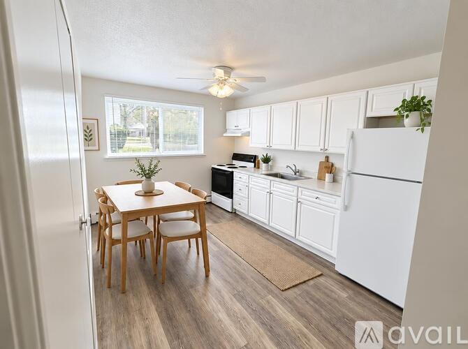 A kitchen with a table and chairs and a fridge.
