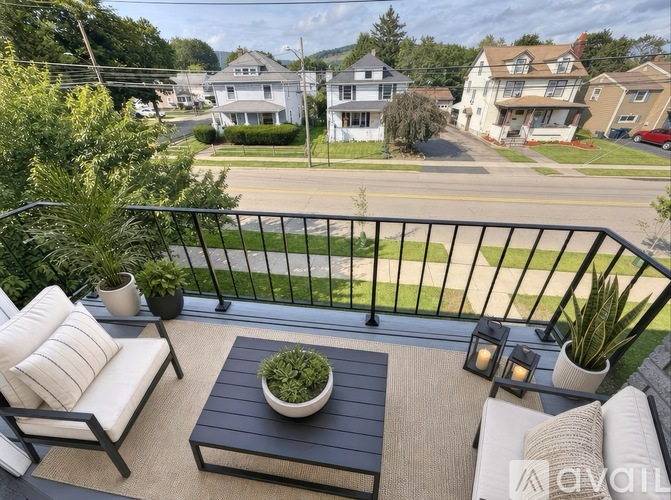 A balcony with a table and chairs overlooking a street.
