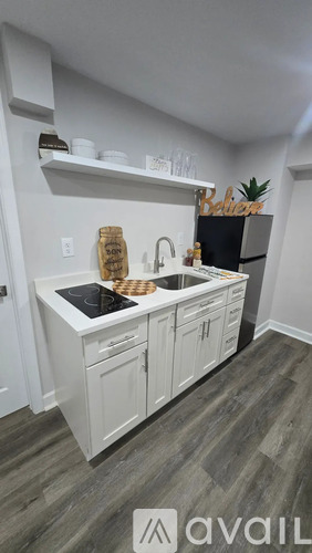 A kitchen with white cabinets and a black stove top.