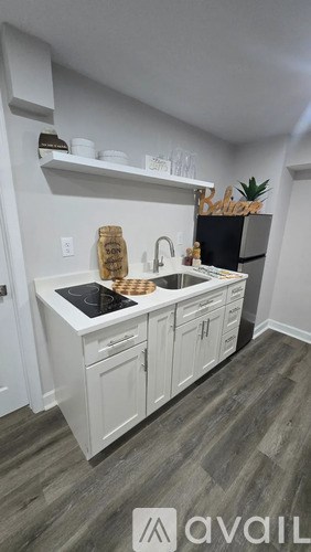 A kitchen with white cabinets and a black stove top.