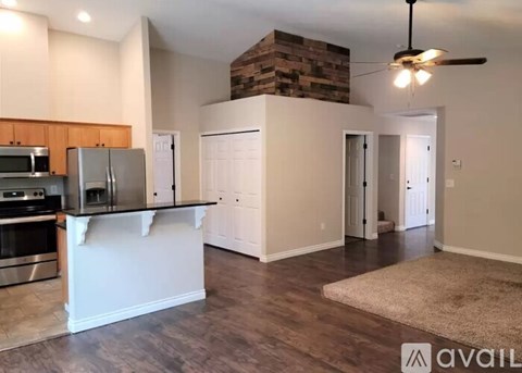 A kitchen with a refrigerator, microwave, and oven.
