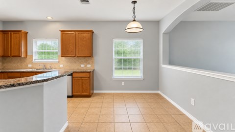A kitchen with wooden cabinets and a marble countertop.