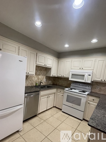 A kitchen with white cabinets and appliances.
