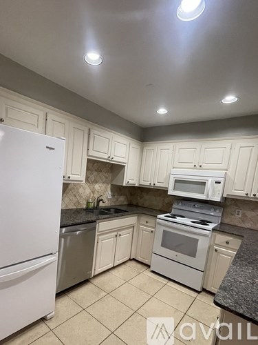 A kitchen with white cabinets and appliances.