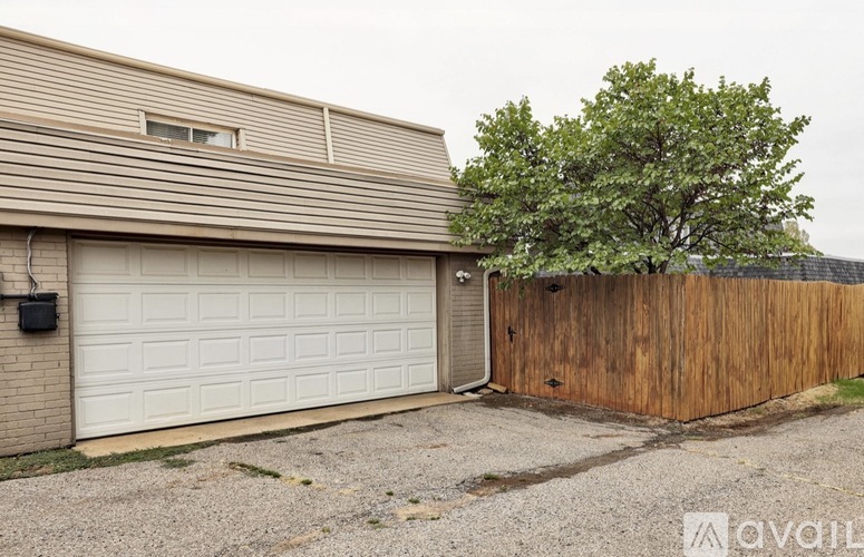 A house with a white garage door and a wooden fence.
