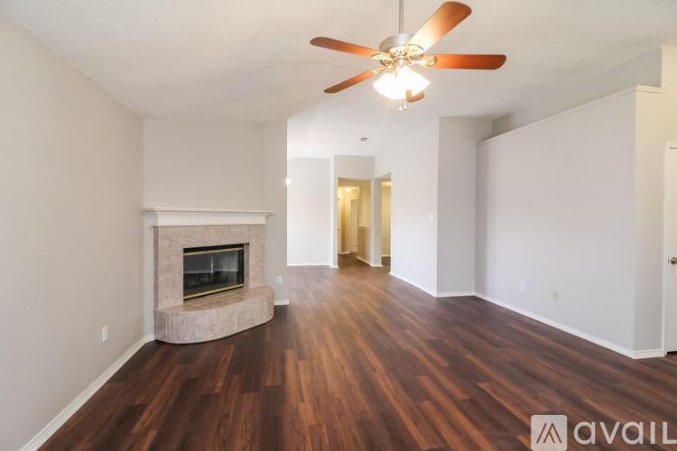 A living room with a fireplace and wood flooring.