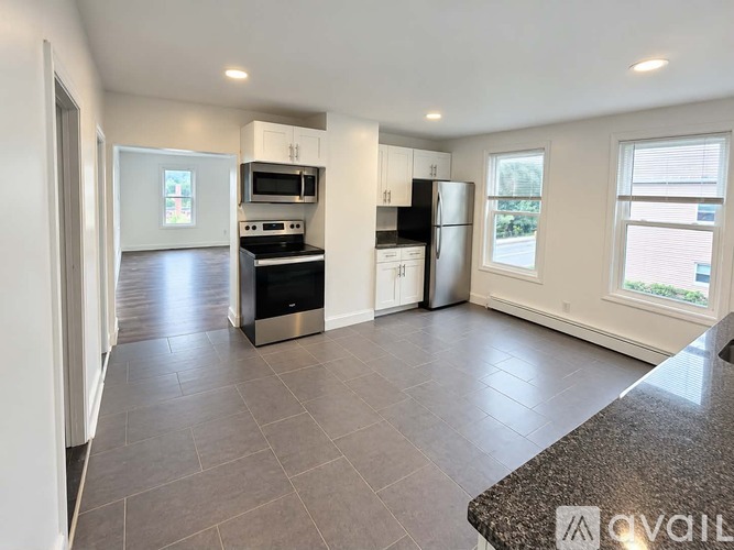 A kitchen with a black fridge and stove top oven.