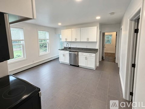 A kitchen with white cabinets and a black stove top oven.