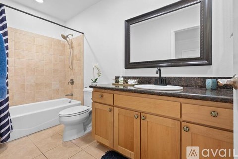A bathroom with a toilet, sink, and a mirror.