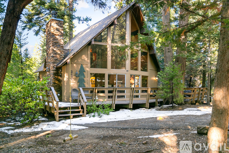 A cabin in the woods with a porch and a wood stove.