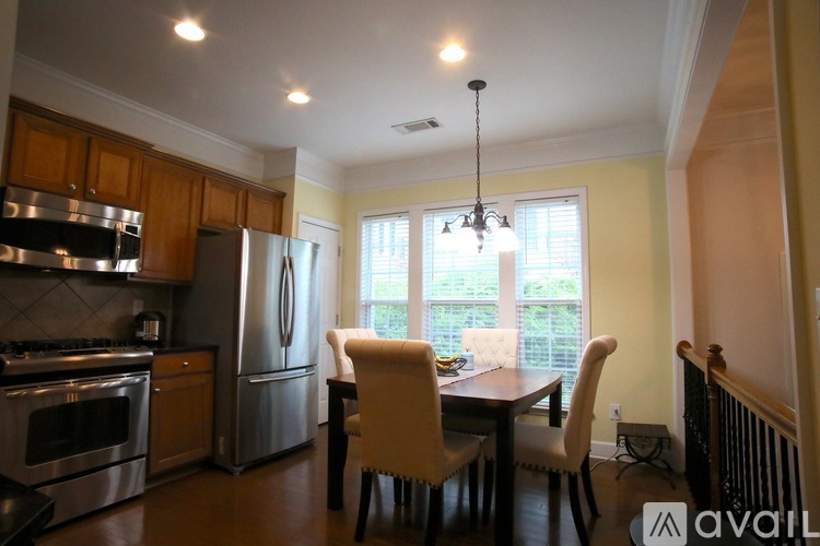 A kitchen with a table and chairs in front of a window.