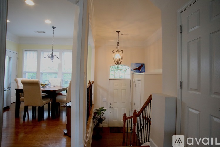A dining room with a table and chairs is visible through a doorway.