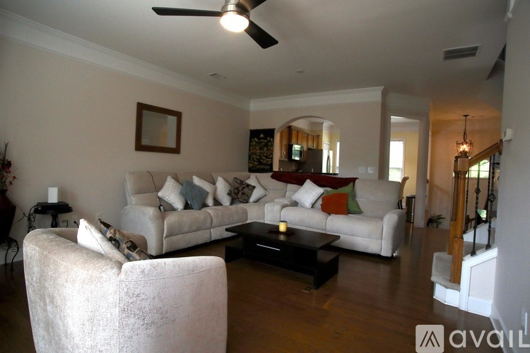 A living room with a white couch and a ceiling fan.