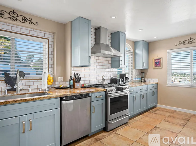 A kitchen with blue cabinets and a tile backsplash.