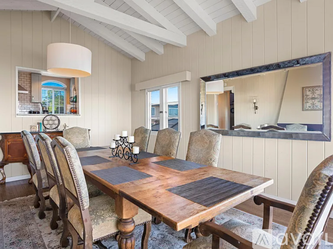 A dining room with a wooden table and chairs.