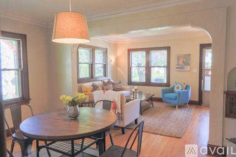 A living room with a round table and chairs.