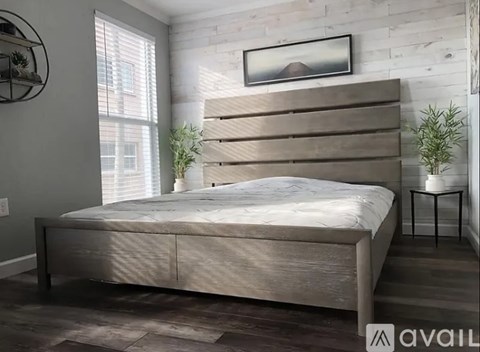 A bedroom with a large bed and a picture on the wall.
