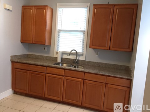A kitchen with brown cabinets and a granite countertop.